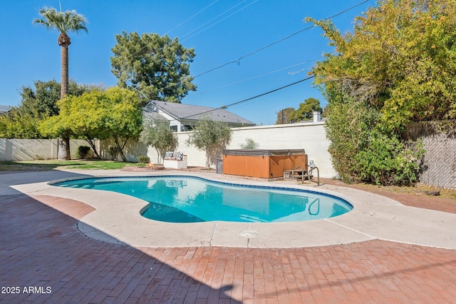 view of swimming pool with a hot tub and a patio