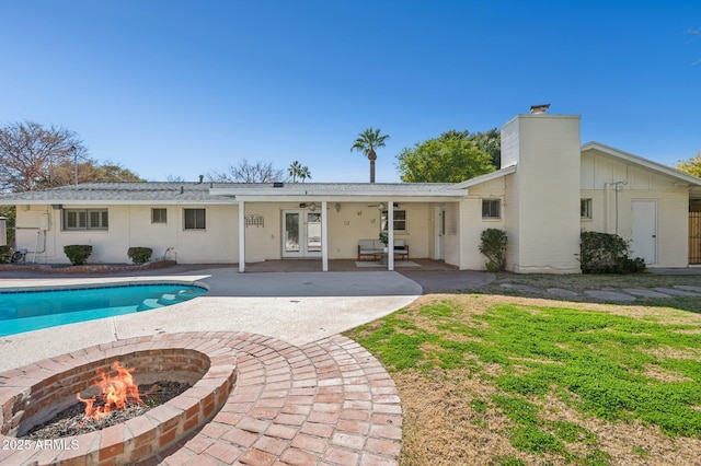 rear view of house featuring a patio area and an outdoor fire pit