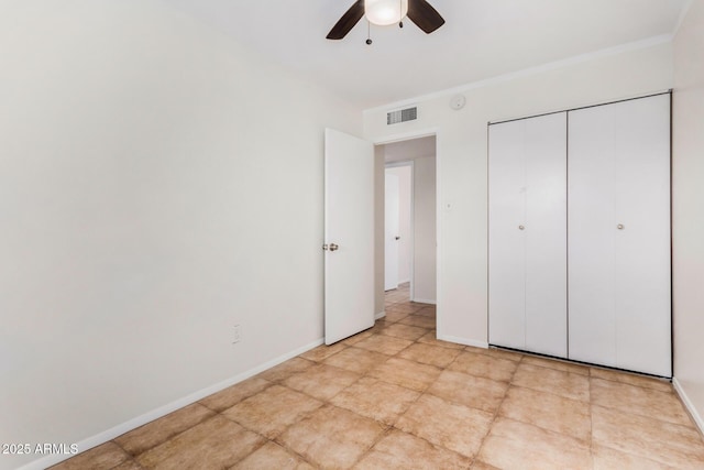 unfurnished bedroom featuring ceiling fan, ornamental molding, and a closet