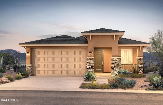 prairie-style house featuring a garage and a mountain view