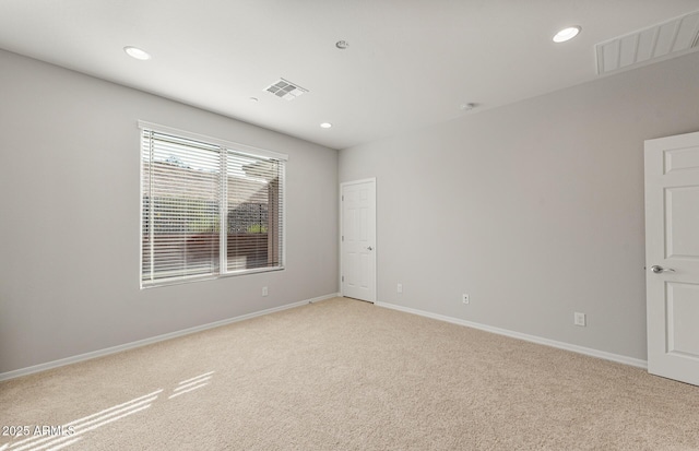 spare room featuring light colored carpet