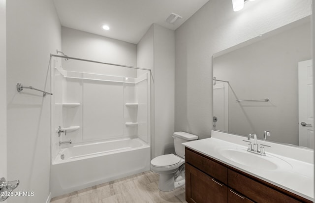 full bathroom featuring vanity, hardwood / wood-style floors, toilet, and washtub / shower combination