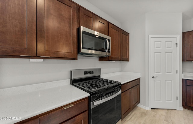 kitchen featuring stainless steel appliances and dark brown cabinets