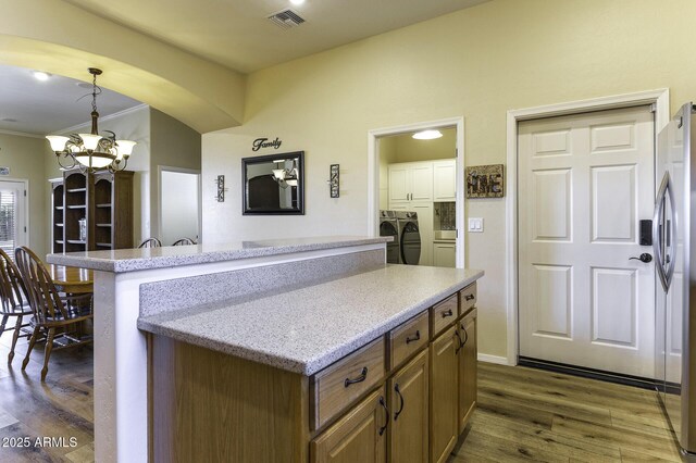 1123 E Shepherds Way, Casa Grande, AZ 85122 - kitchen with washer and dryer, stainless steel fridge, dark wood finished floors, a center island, and a chandelier