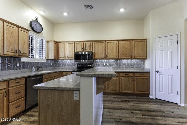 1123 E Shepherds Way, Casa Grande, AZ 85122 - kitchen with appliances with stainless steel finishes, a sink, decorative backsplash, a center island, and dark wood-style flooring
