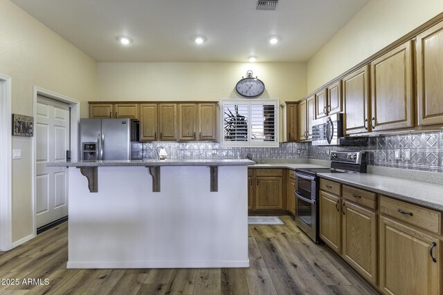 1123 E Shepherds Way, Casa Grande, AZ 85122 - kitchen with appliances with stainless steel finishes, a breakfast bar, backsplash, light stone countertops, and recessed lighting