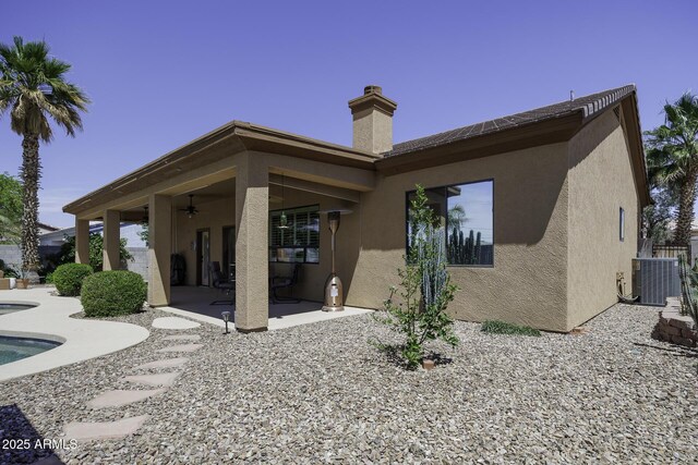 1123 E Shepherds Way, Casa Grande, AZ 85122 - back of property featuring a patio area, stucco siding, a ceiling fan, central AC unit, and a chimney