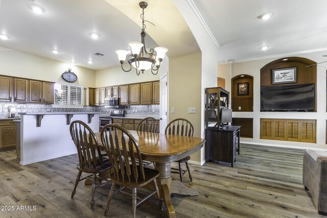 1123 E Shepherds Way, Casa Grande, AZ 85122 - dining area with a chandelier, arched walkways, crown molding, wood finished floors, and recessed lighting