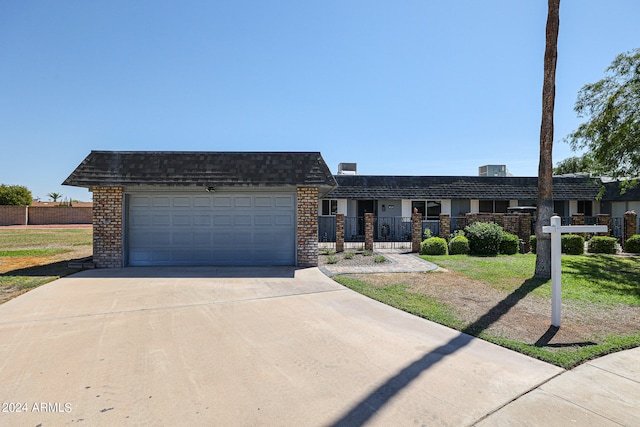 ranch-style home with a garage and a front lawn