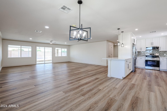 kitchen with backsplash, appliances with stainless steel finishes, light hardwood / wood-style floors, hanging light fixtures, and white cabinets