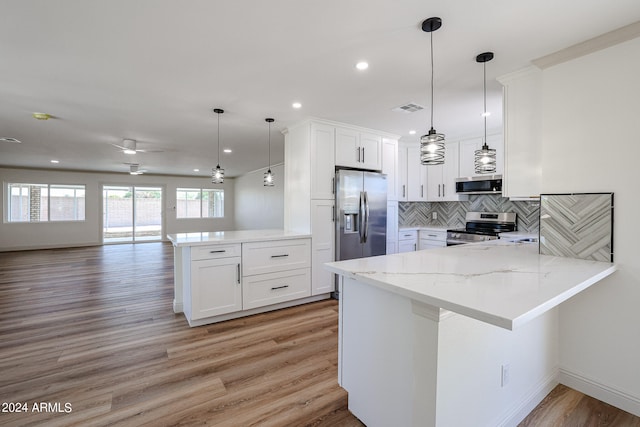 kitchen featuring kitchen peninsula, appliances with stainless steel finishes, ceiling fan, and white cabinets