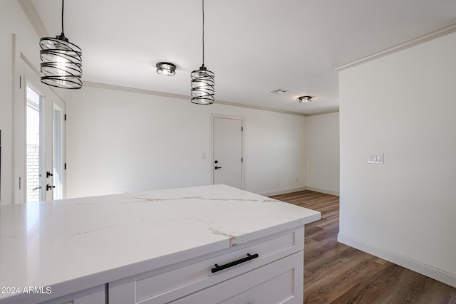 kitchen with crown molding, wood finished floors, light stone countertops, and pendant lighting