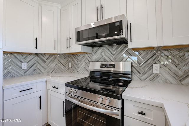 kitchen featuring white cabinetry, light stone counters, stainless steel appliances, and tasteful backsplash