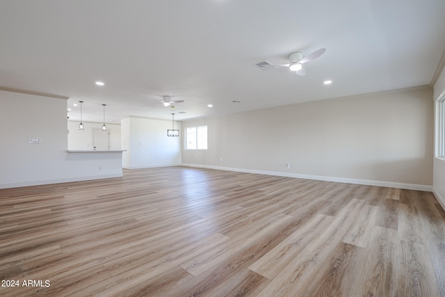 unfurnished living room featuring ceiling fan, ornamental molding, and light hardwood / wood-style floors