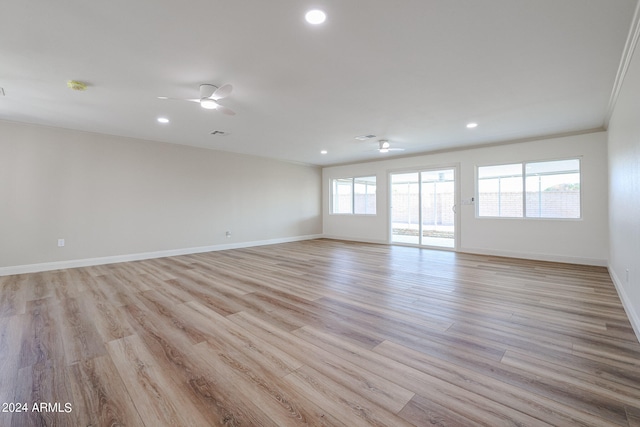 unfurnished room featuring ceiling fan, light hardwood / wood-style floors, and a healthy amount of sunlight