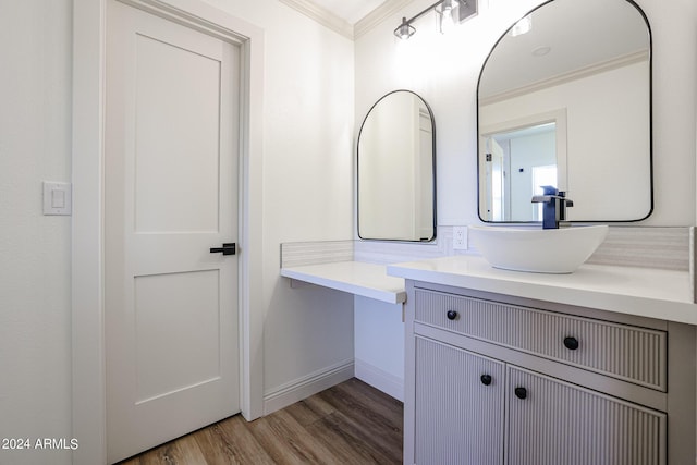 bathroom with vanity, wood finished floors, baseboards, and ornamental molding