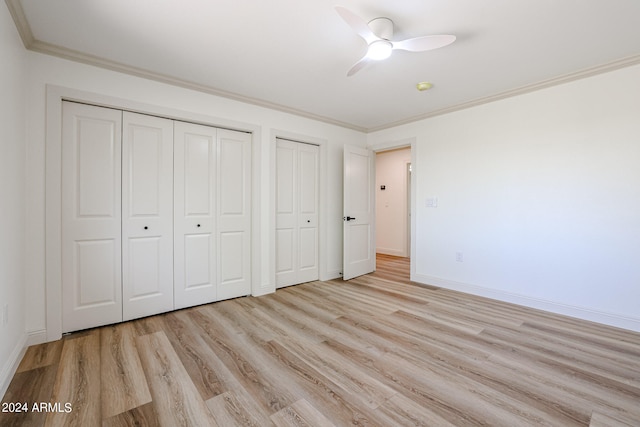 unfurnished bedroom with crown molding, ceiling fan, two closets, and light hardwood / wood-style floors