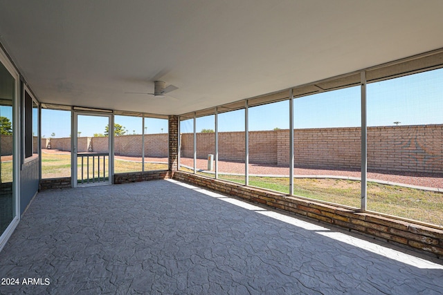 unfurnished sunroom featuring ceiling fan