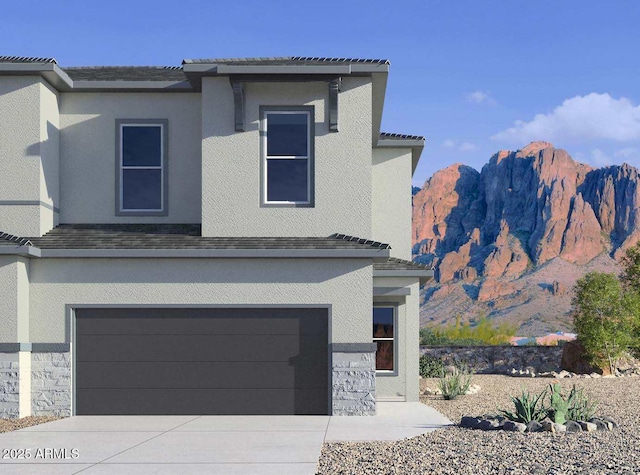 5844 E Covey Ln, Phoenix, AZ 85054 - view of front of house featuring a garage, concrete driveway, stucco siding, and a mountain view