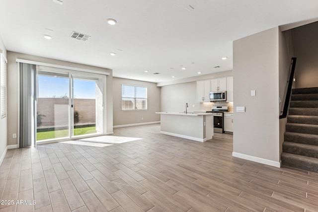 5844 E Covey Ln, Phoenix, AZ 85054 - unfurnished living room with a sink, light wood-style flooring, baseboards, stairs, and recessed lighting
