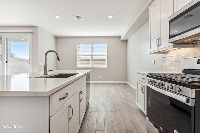 5844 E Covey Ln, Phoenix, AZ 85054 - kitchen with stainless steel appliances, a sink, decorative backsplash, light wood-style flooring, and baseboards