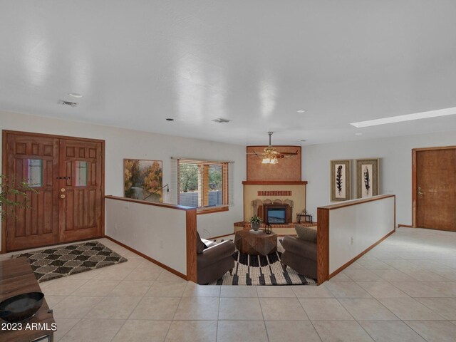 tiled entryway featuring an inviting chandelier and a large fireplace