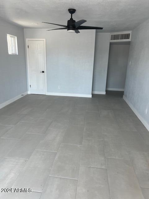 empty room featuring ceiling fan and tile patterned flooring