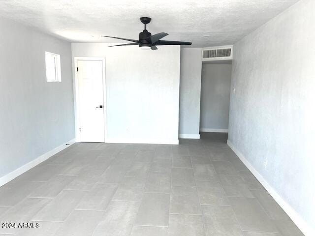 tiled empty room with ceiling fan