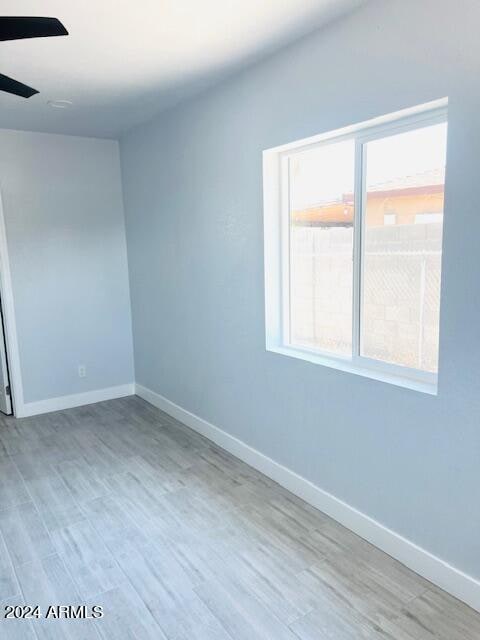 spare room featuring wood-type flooring and ceiling fan