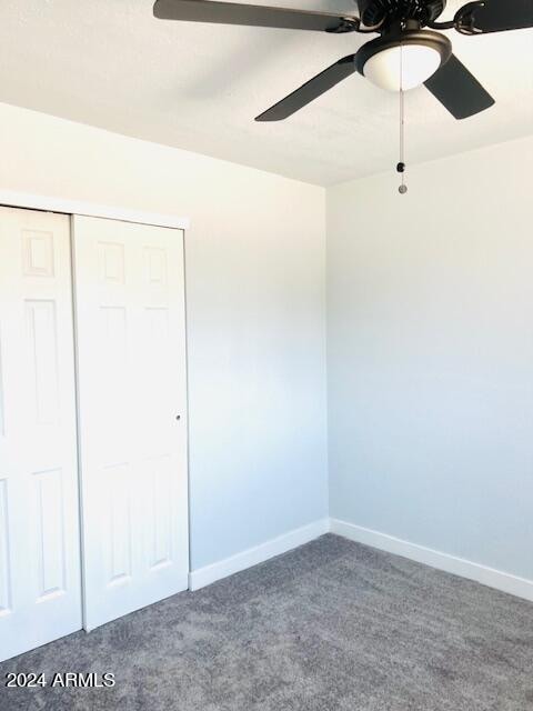 unfurnished bedroom with carpet floors, ceiling fan, and a closet