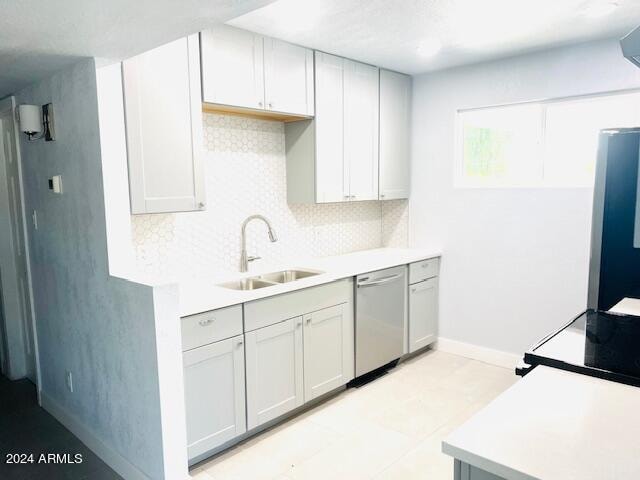 kitchen with range, sink, light tile patterned floors, decorative backsplash, and dishwasher