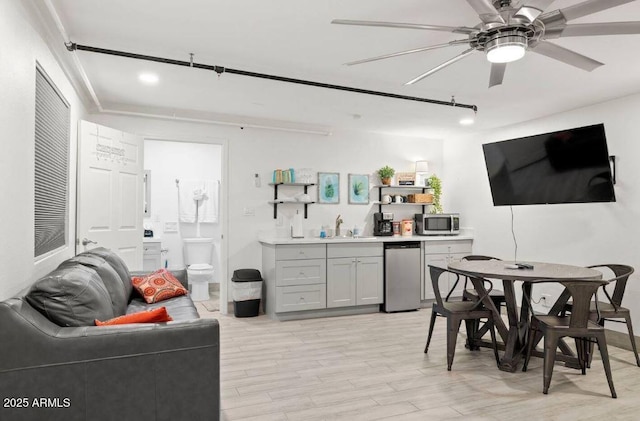 kitchen featuring sink, gray cabinetry, appliances with stainless steel finishes, ceiling fan, and light hardwood / wood-style floors