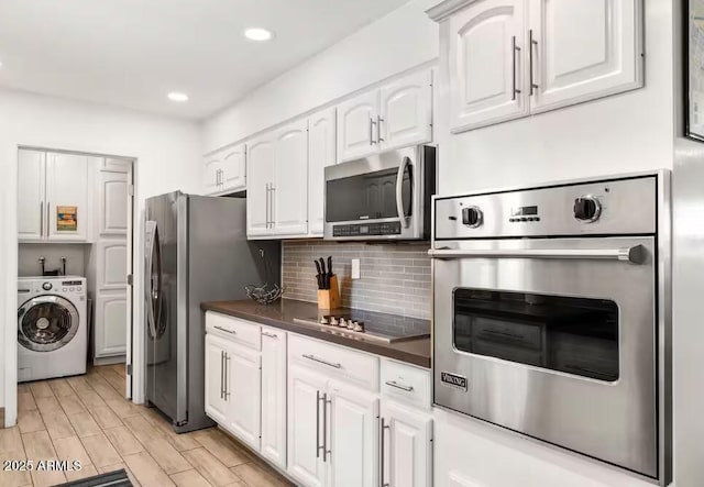 kitchen featuring white cabinetry, washer / dryer, tasteful backsplash, and appliances with stainless steel finishes