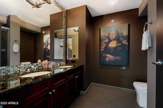 full bath featuring baseboards, toilet, and a sink