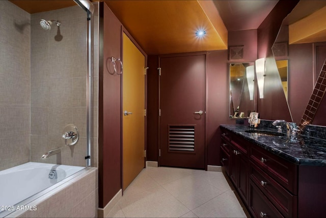 bathroom with tile patterned floors, vanity, and tiled shower / bath