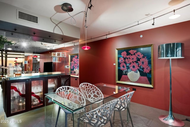dining area featuring a bar, rail lighting, tile patterned flooring, and visible vents