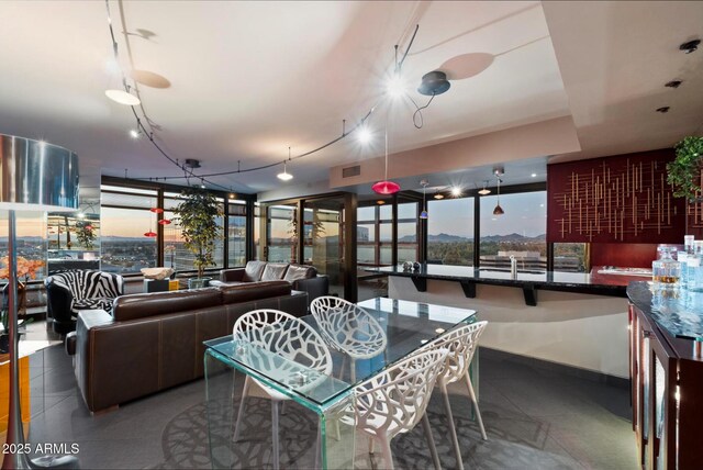 dining space featuring rail lighting, baseboards, and visible vents