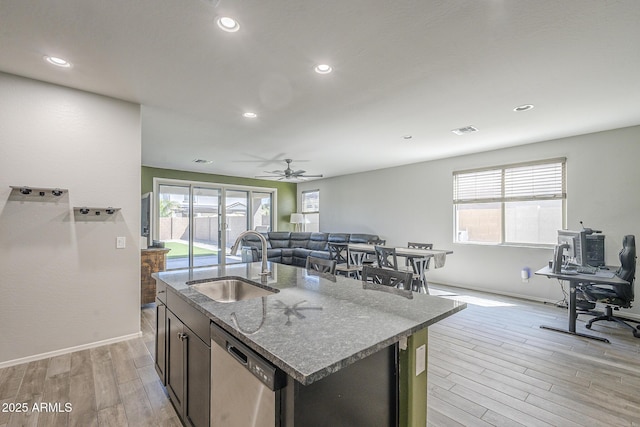 9934 E Orange Grove St, Florence, AZ 85132 - kitchen featuring stainless steel dishwasher, light wood-type flooring, dark stone countertops, a ceiling fan, and open floor plan