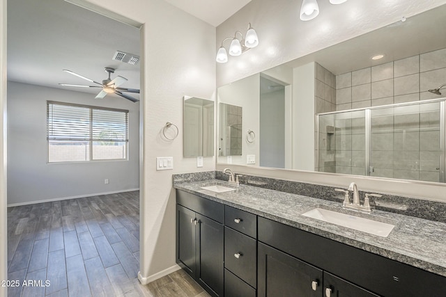 9934 E Orange Grove St, Florence, AZ 85132 - bathroom with double vanity, a shower stall, wood finished floors, and ceiling fan