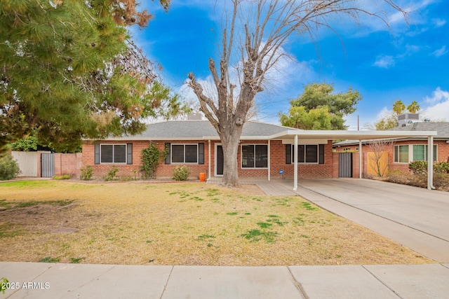 ranch-style home featuring a carport and a front lawn