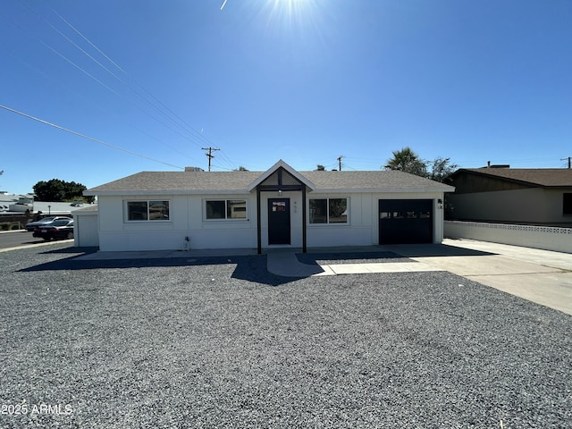 ranch-style home featuring driveway, roof with shingles, and an attached garage