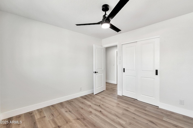 unfurnished bedroom with ceiling fan, a closet, light wood-type flooring, and baseboards