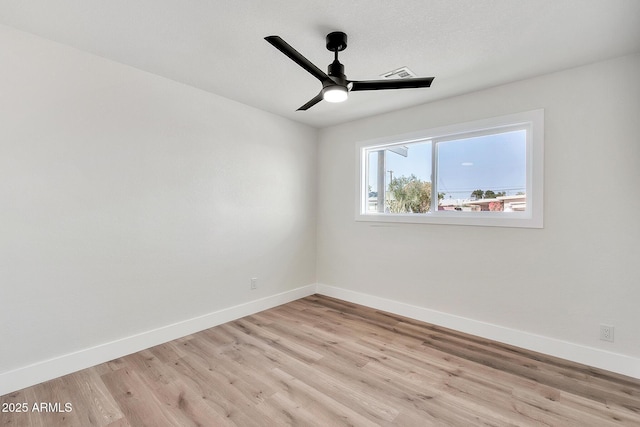 empty room featuring light wood-type flooring, visible vents, baseboards, and a ceiling fan