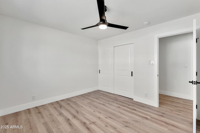 unfurnished bedroom with a closet, baseboards, and light wood finished floors