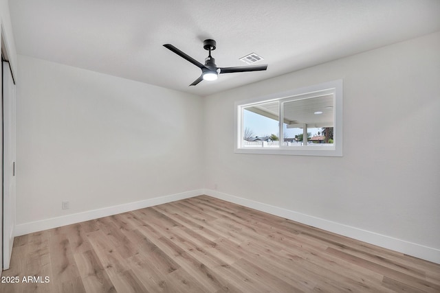 empty room featuring light wood-style flooring, visible vents, ceiling fan, and baseboards