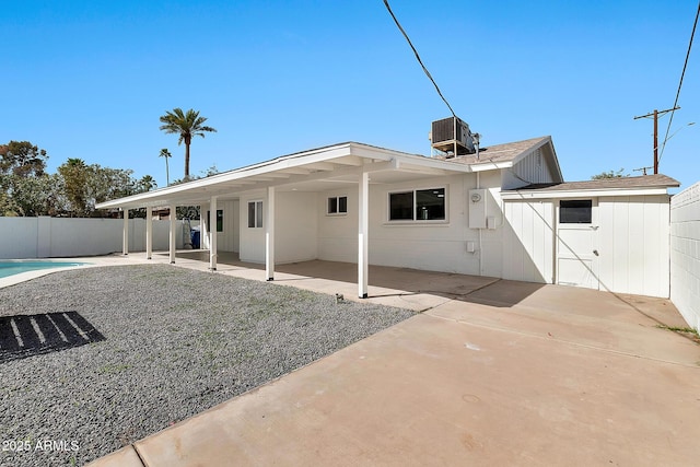 rear view of house with a patio, central AC unit, fence, and a fenced in pool