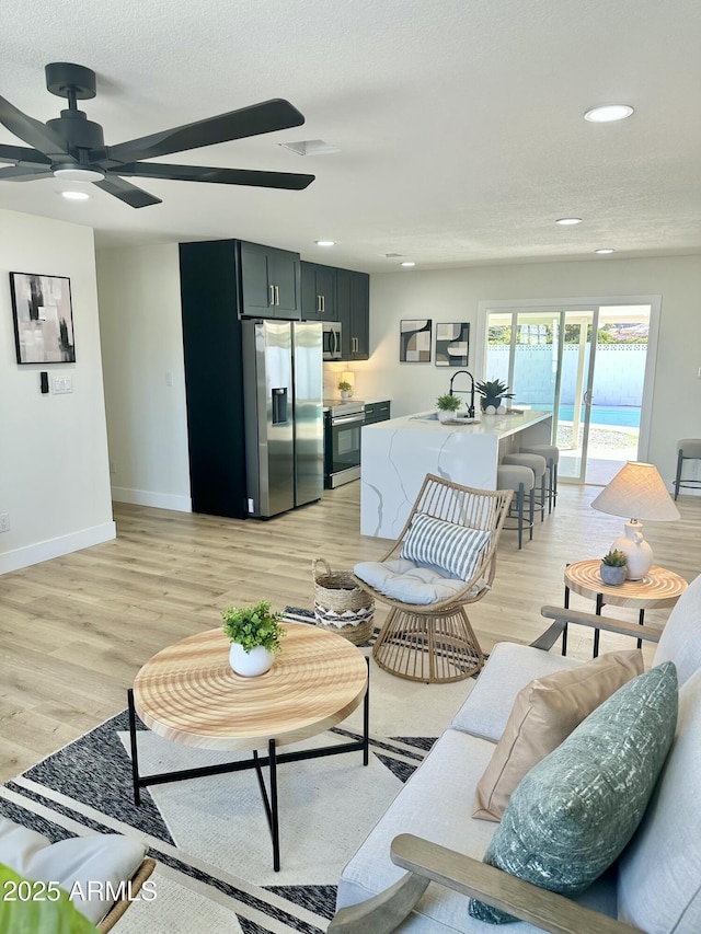 living area with light wood finished floors, recessed lighting, visible vents, ceiling fan, and baseboards