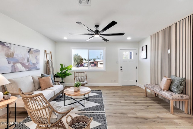 living room featuring light wood finished floors, baseboards, visible vents, and recessed lighting