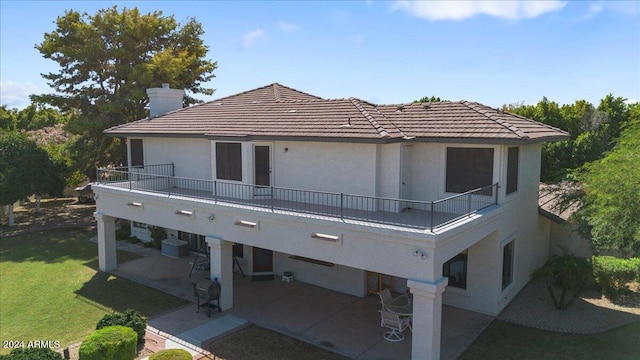 back of house with a lawn, a balcony, and a patio