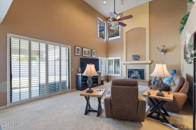 living room featuring carpet, a high ceiling, and ceiling fan